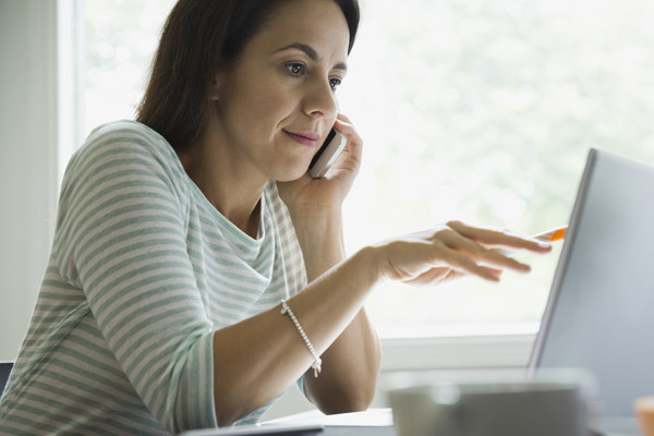 A woman looks at a laptop
