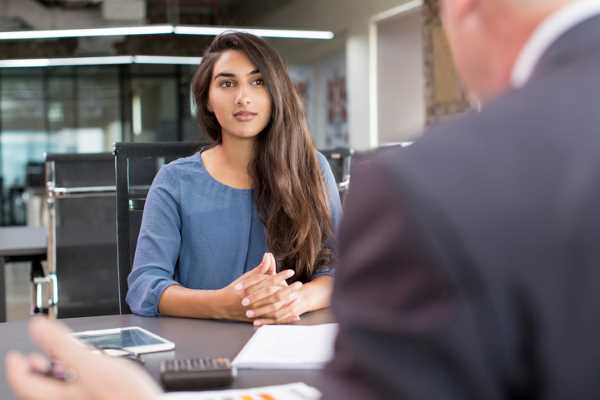 A job applicant sits at a desk during a job interview.