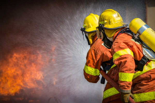 Firemen spray water on a fire
