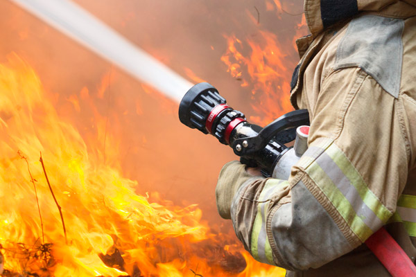 A fireman sprays water on a fire