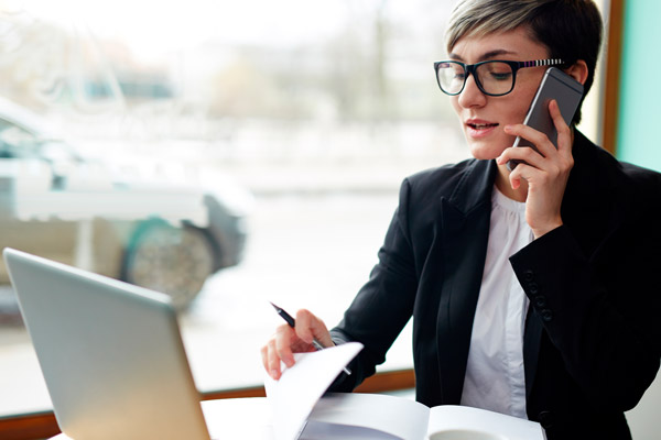 A woman sits at a desk in front of a laptop