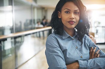 A woman stands confidently in an office