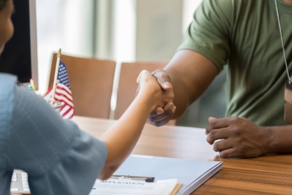 A veteran entrepreneur shakes hands with a client.