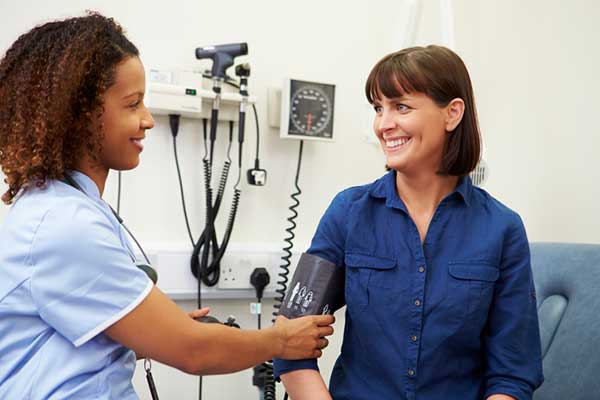 A nurse takes a patient's blood pressure