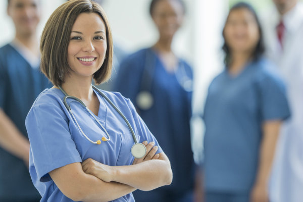 A group of nurses standing and smiling at the camera.