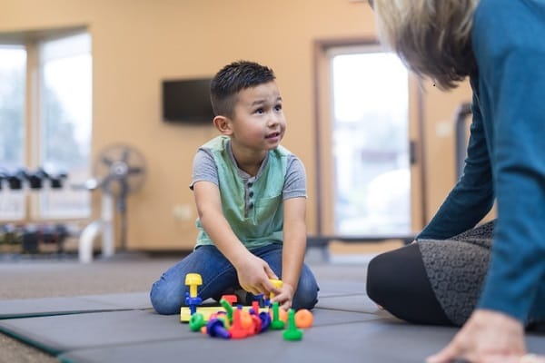 Image concept of an adult sitting on a floor in a business setting with a young child
