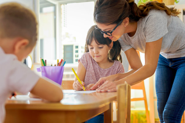 Early childhood professional helping a young girl