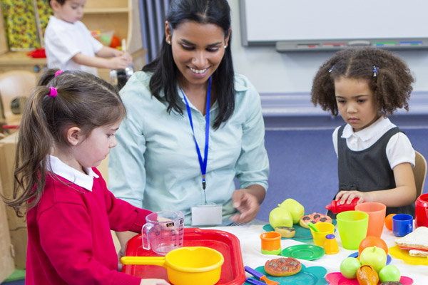A teacher sits with two children