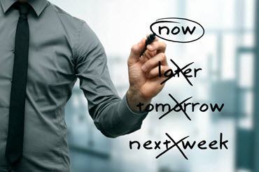A man writes different timing options on a screen and circles the word "now."