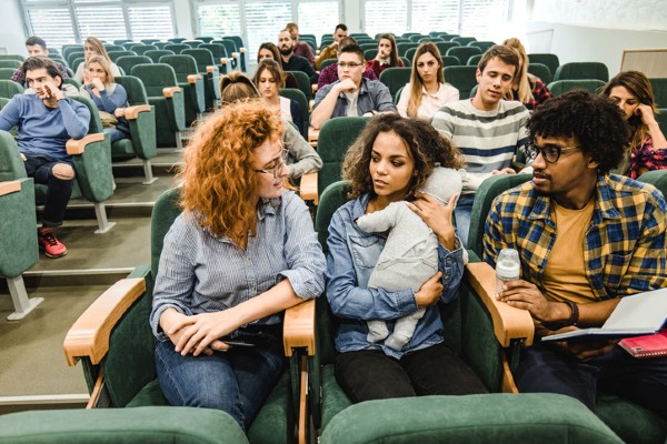 A mother cuddles her infant in her college classroom