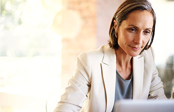 Businesswomen in suit jacket working at a computer