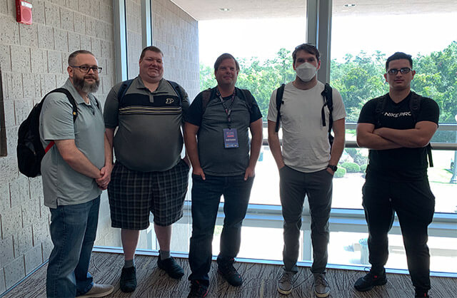 Purdue Global students Andre Coronado, Jacob Mack, Michael Staats, and Nicholas Huser standing in a lobby