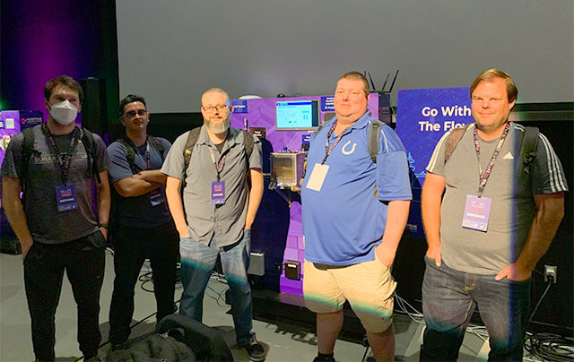 Purdue Global students Andre Coronado, Jacob Mack, Michael Staats, Nicholas Huser, and Wyn Forsterat standing on the floor of the Hack the Port 2022 cybersecurity competition
