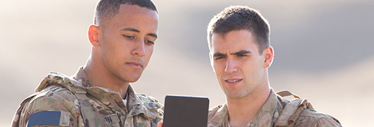 2 men in uniform looking at a tablet